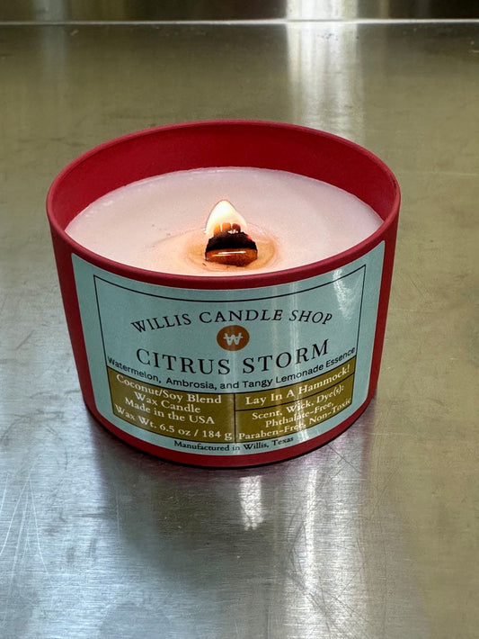 Citrus Storm fragrant candle in a red tin candle container with wood wick.