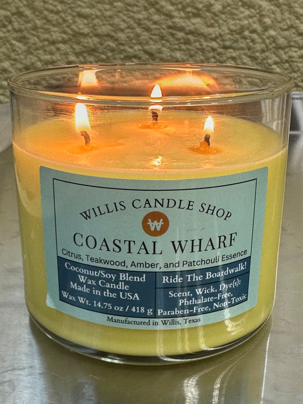 Coastal Wharf scented candle as 3 wick candle burning at Willis Candle Shop.
