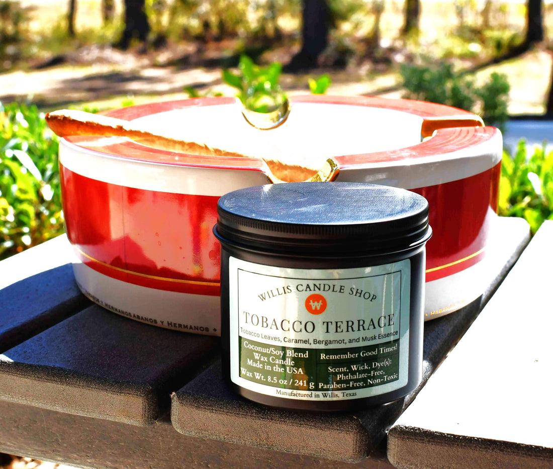 Tobacco candle staged outdoors next to an ashtray with a cigar.