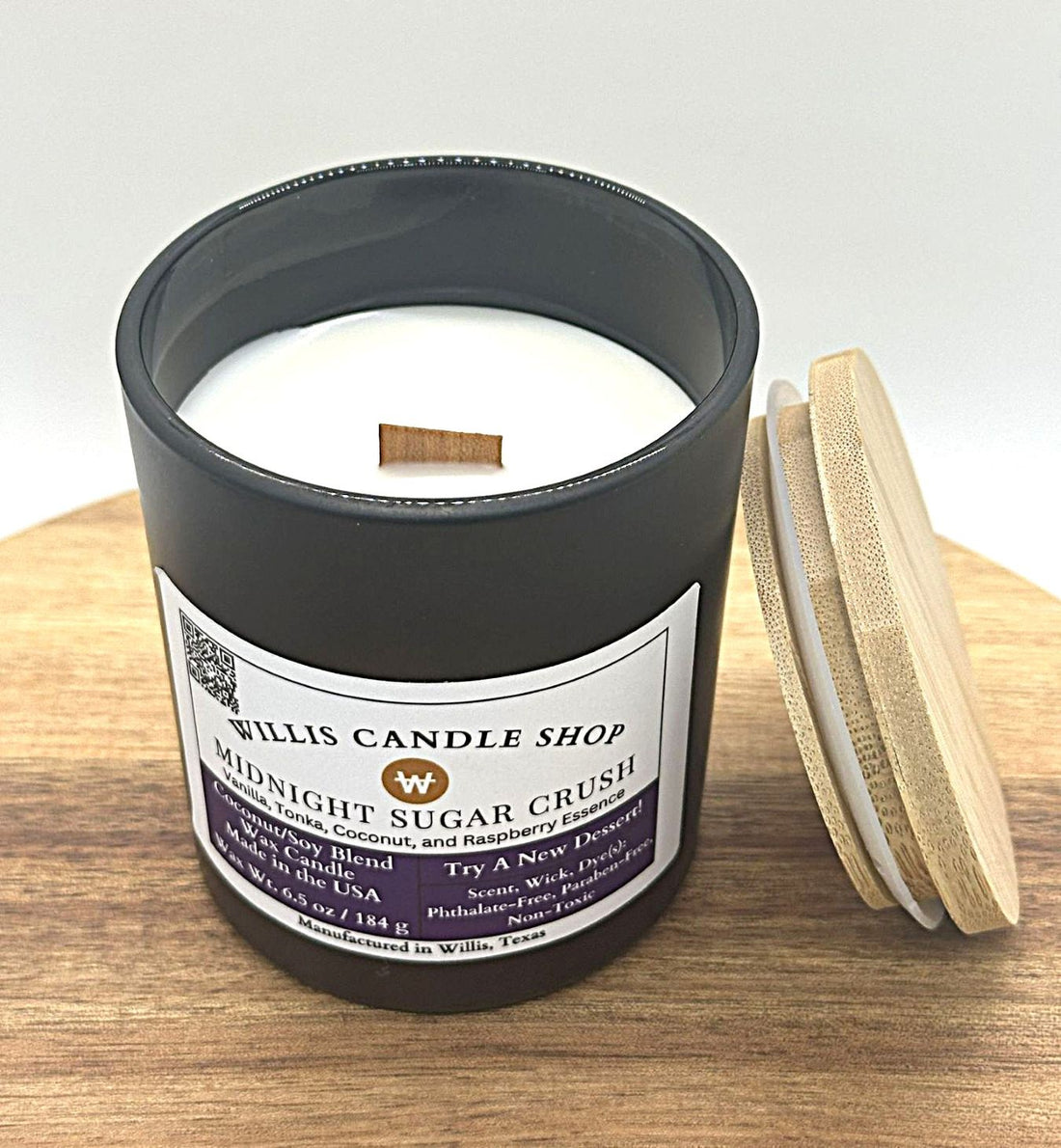 Wood wick candle with Midnight Sugar Crush scent in a black solid container with bamboo lid.