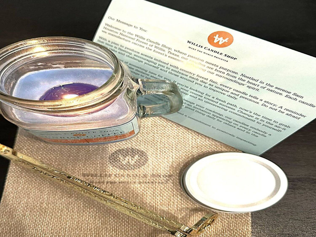 Mug jar scented candle burning on top of a burlap bag with candle care card.