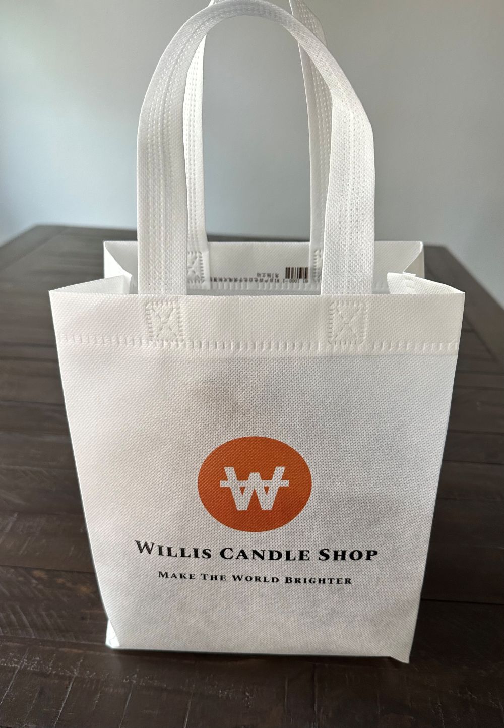 Willis Candle Shop logo bag with white strap.