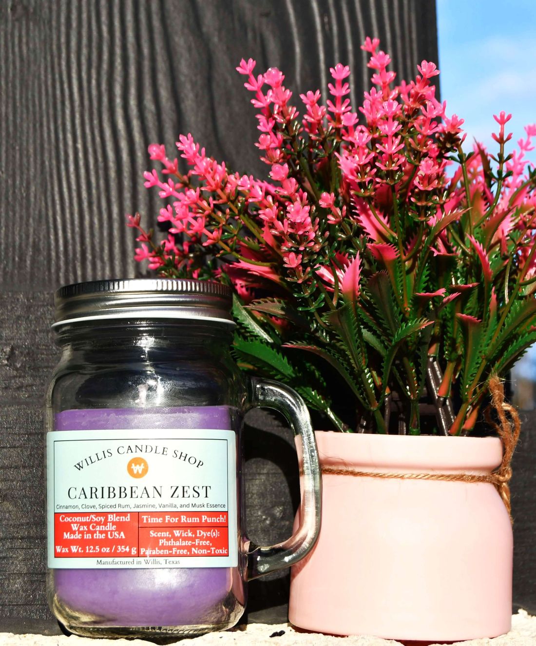 Caribbean Zest candle with violet candle wax color outdoors.