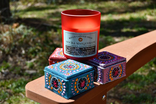 Red frosted glass candle next to knick-knacks on red arm chair.
