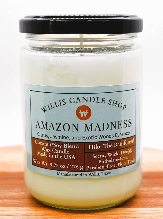 Jar of candle labeled 'Amazon Madness' from Willis Candle Shop on a wooden surface.