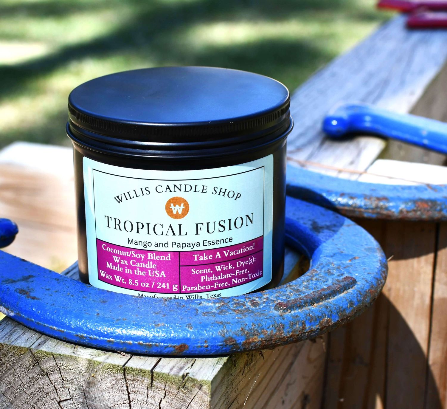 Black tin candle on horseshoe pit with Tropical Fusion scented candle option at Willis Candle Shop.
