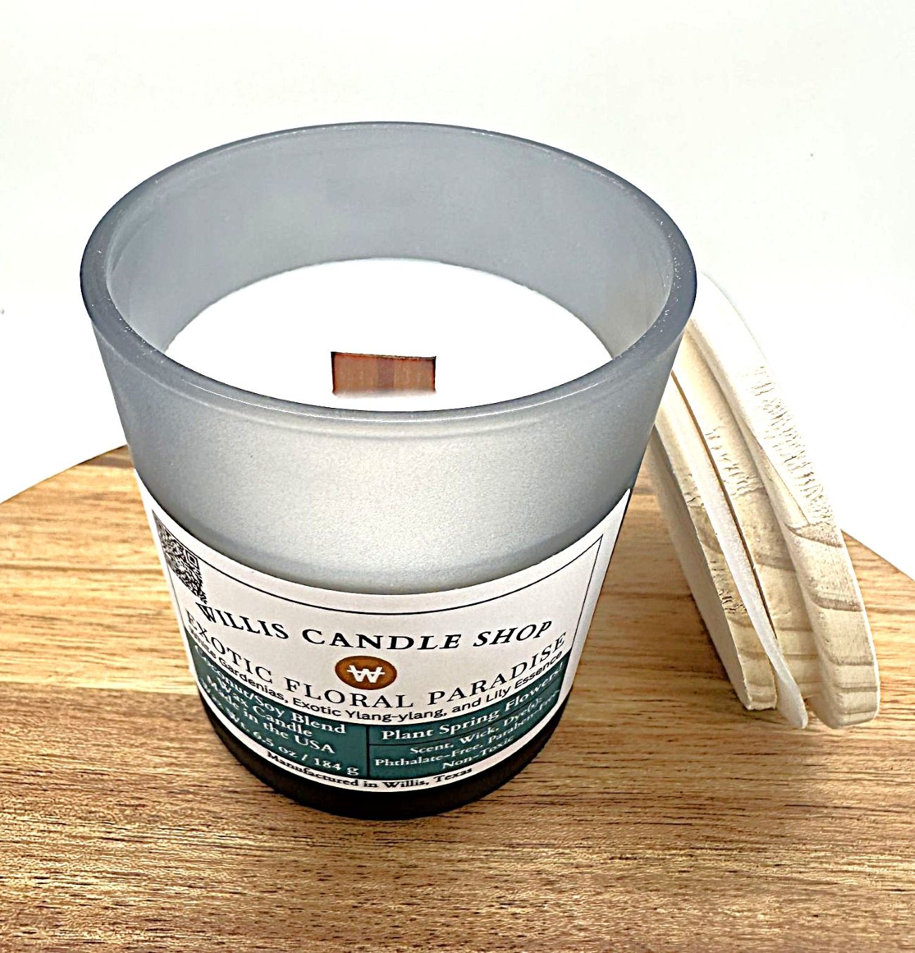 Frosted black glass candle with wood wick and bamboo lid and floral scent.