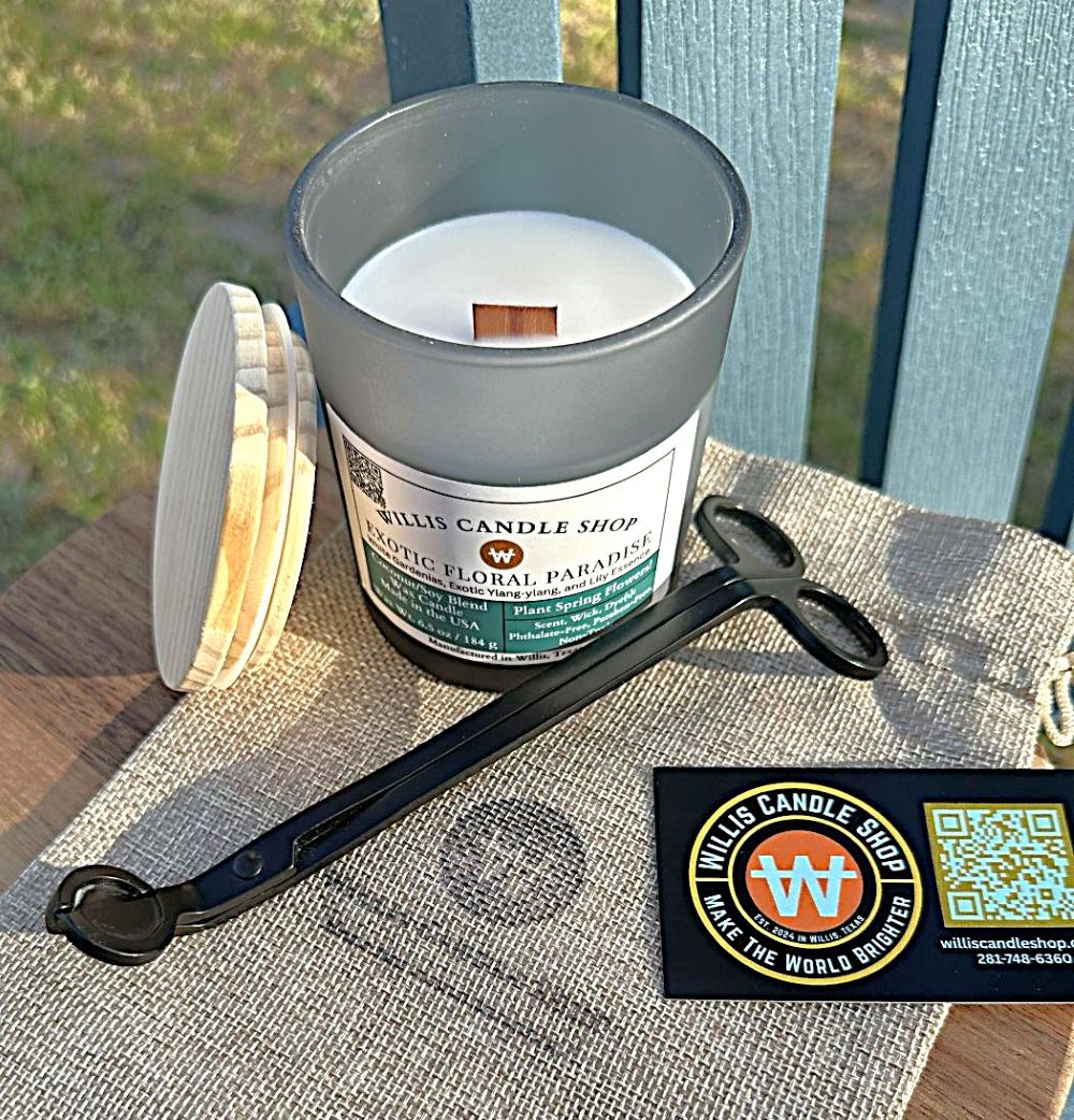 Black frosted glass candle with bamboo lid leaning against candle on a burlap bag.