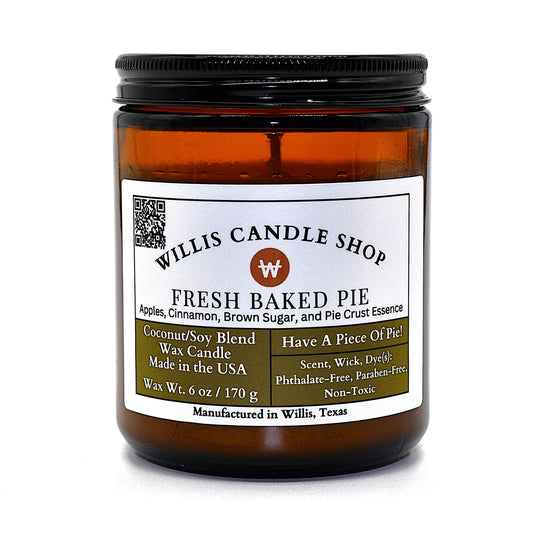 A 6 oz amber glass jar candle with a black metal lid and a white label from Willis Candle Shop, labeled 'Fresh Baked Pie'.