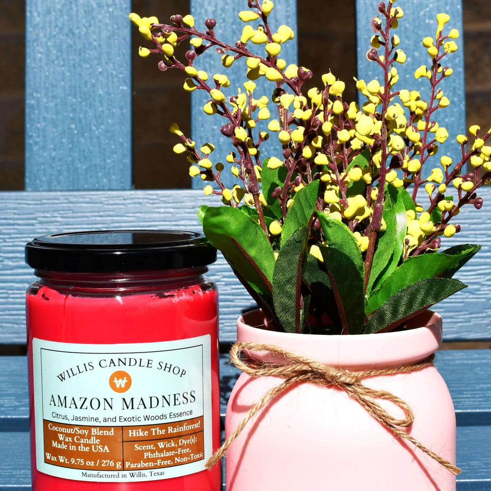 Red coconut and soy 25/75 blended candle with Citrus, Jasmine Amazon Madness Fragrance in a glass jar with a black lid.