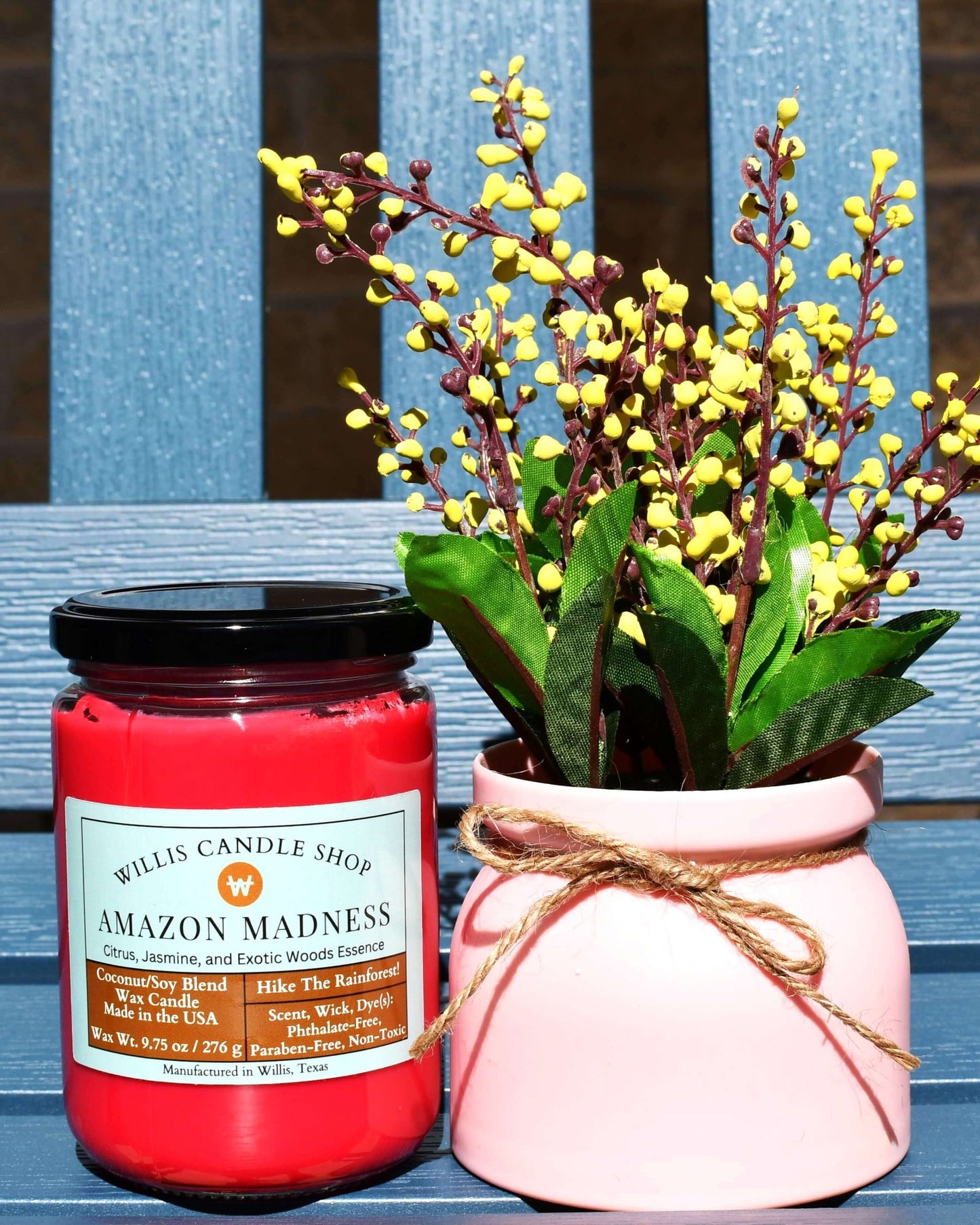 Red coconut and soy 25/75 blended candle with Citrus, Jasmine Amazon Madness Fragrance in a glass jar with a black lid.