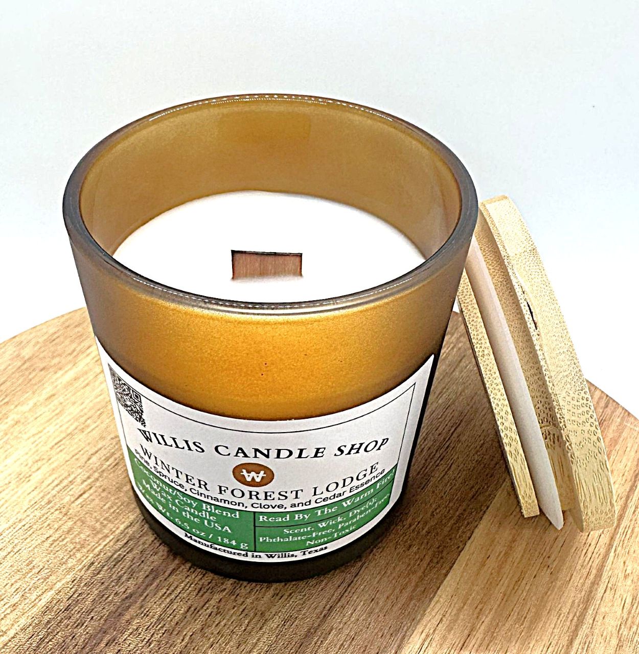 Frosted amber candle with wood wick and Winter Forest Lodge scent with bamboo lid.