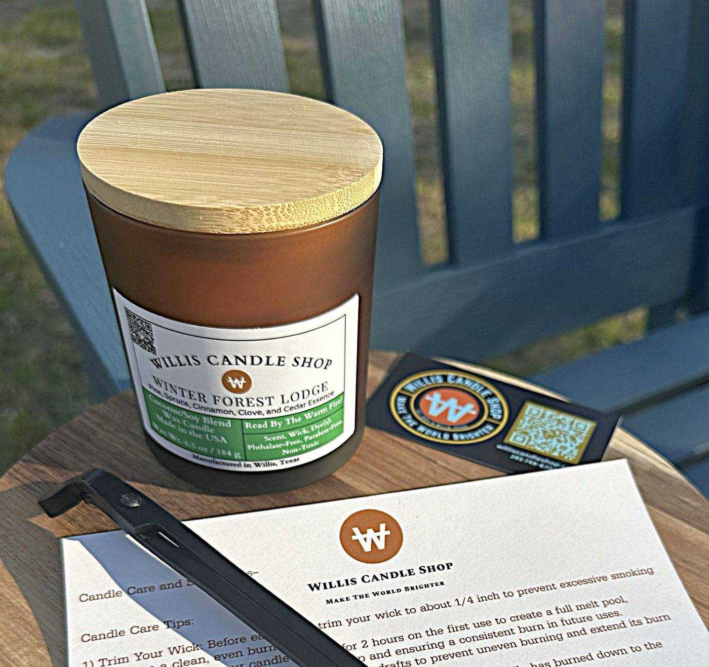 Amber frosted candle vessel with wick trimmer and candle care card outside in Willis, Texas.