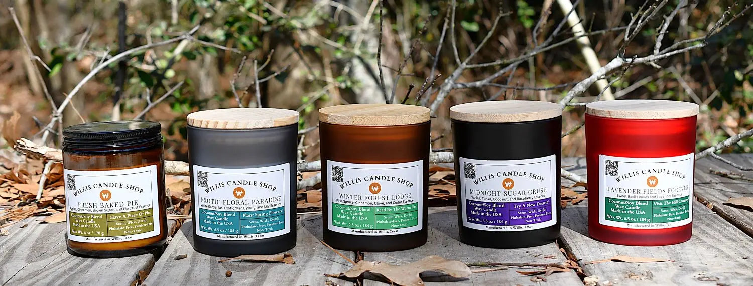 Five candles of different colors and scents on a wooden surface with a natural background.