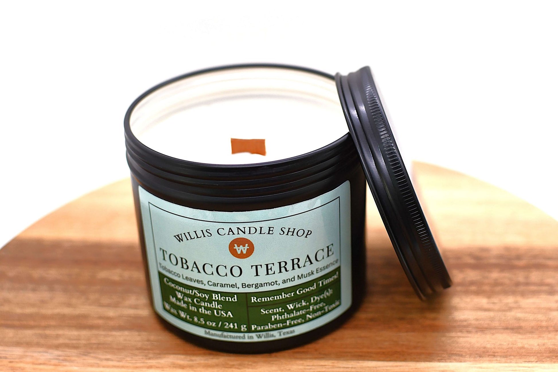 Candle jar labeled 'Tobacco Terrace' from Willis Candle Shop on a wooden surface.
